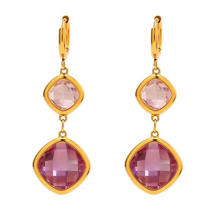 Gold earrings with purple gemstones on a white background