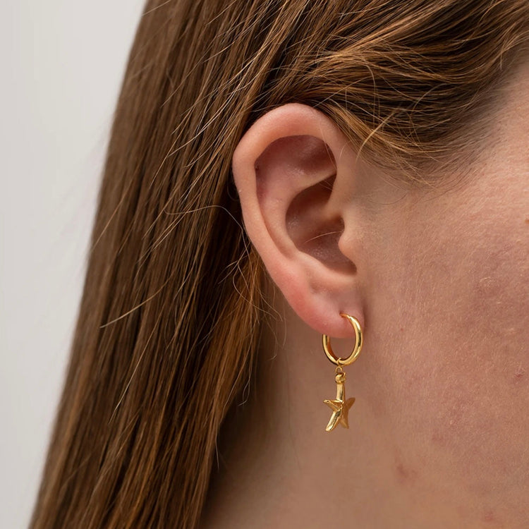 Starfish Huggies Earrings XMTX Collections shown on an ear