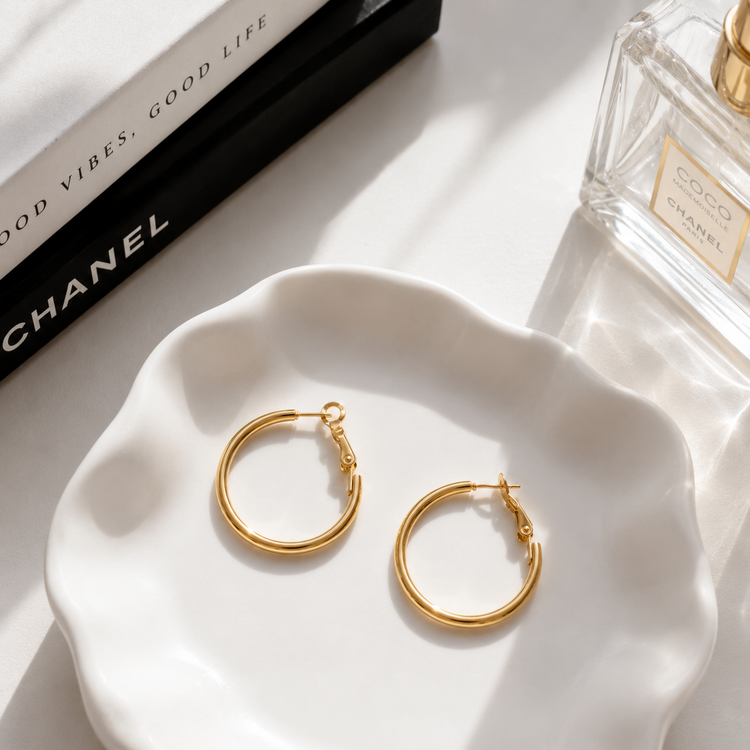 Dulcie waterproof gold hoop earrings styled in a luxury flat lay, featuring a classic polished non-tarnish hoop design