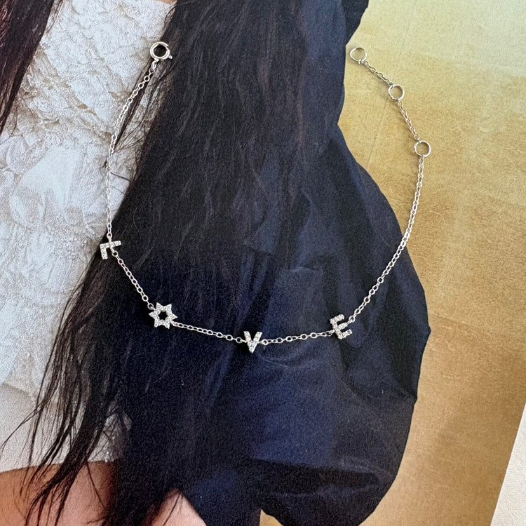 Minimalist sterling silver pavé LOVE bracelet with Mogen David detail editorial styling