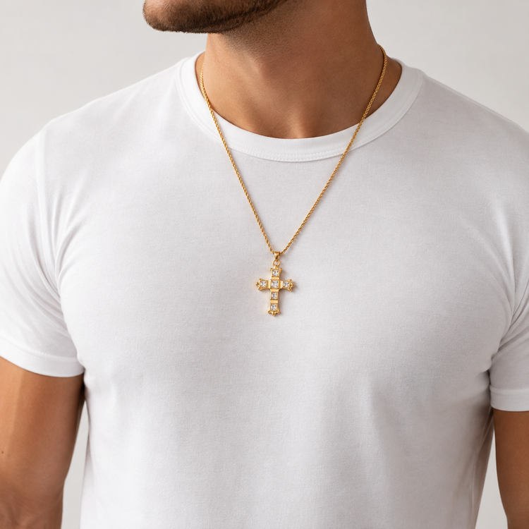 Unisex gold cross necklace with clear stone accents worn on a man