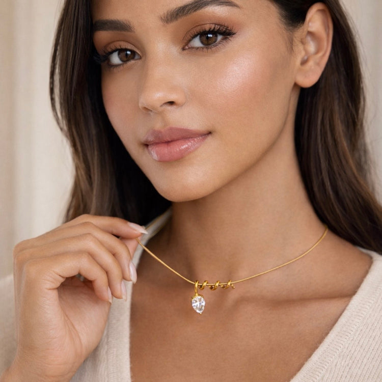 Closeup of Vitelle non tarnish gold teardrop pendant on a model