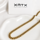 8mm gold Cuban chain necklace displayed on a white ceramic dish