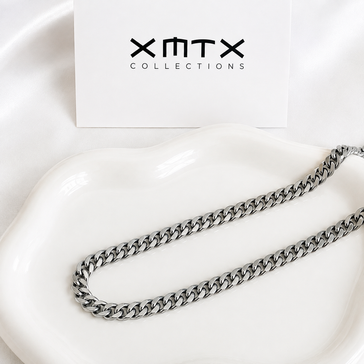 8mm silver Cuban chain necklace displayed on a white ceramic dish