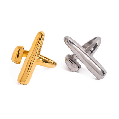 Close-up of hand wearing the Davina adjustable sculptural rings in 18K gold and silver from XMTX Collections, styled on white textured background