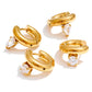 Elle Huggies gold huggie earrings with round and teardrop cubic zirconia stones on white background