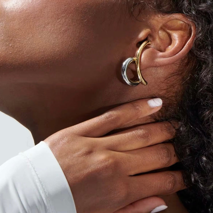 Close-up of woman wearing bold gold and silver Zaria statement hoop earrings by XMTX Collections