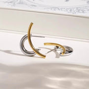 Flat lay of Zaria sculptural hoop earrings in gold and silver from XMTX Collections