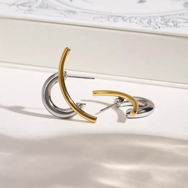  Flat lay of Zaria sculptural hoop earrings in gold and silver from XMTX Collections