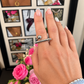 Silver geometric ring with curved bar and round detail worn on hand