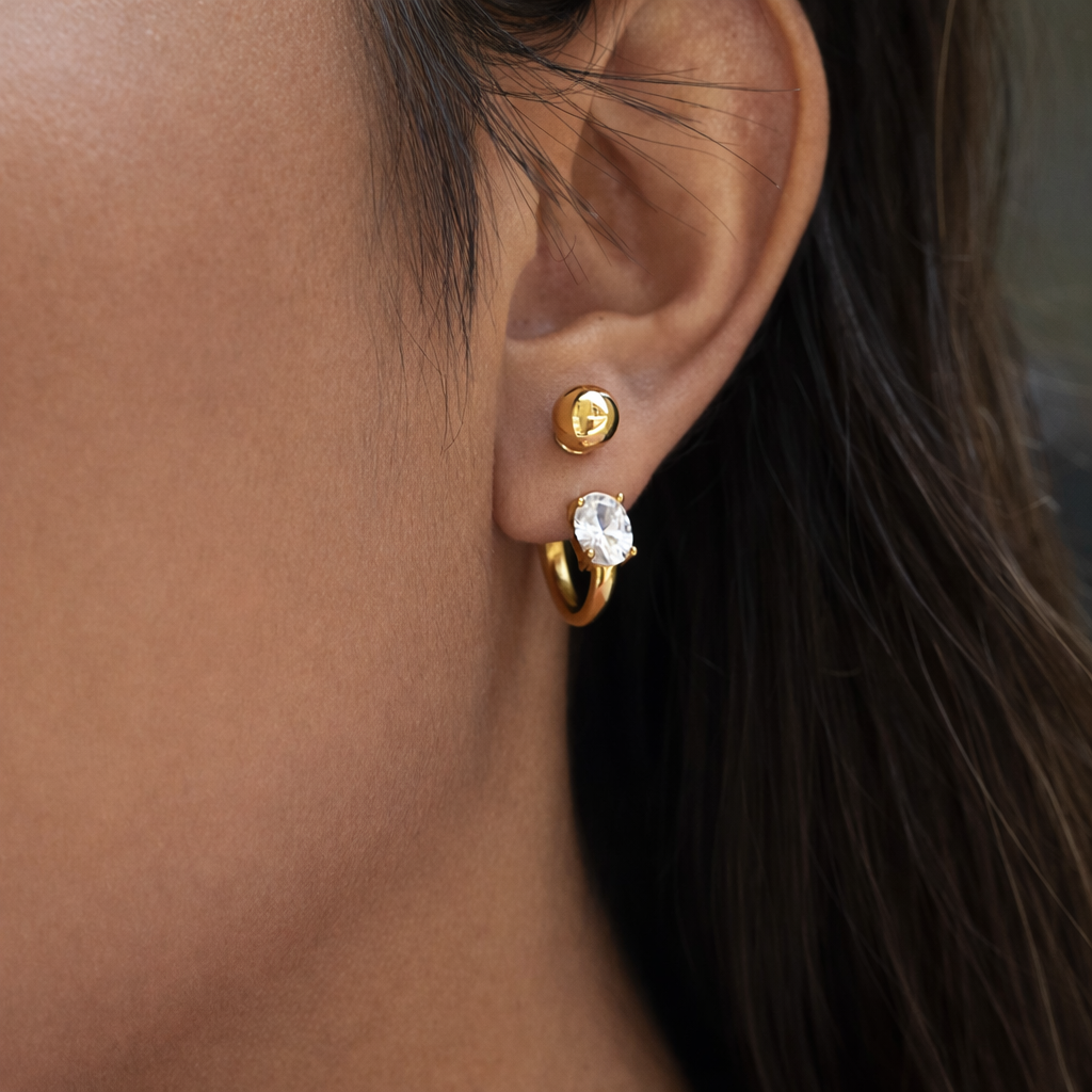 Woman wearing Jordan gold stud hoop earrings waterproof stainless steel with oval cubic zirconia