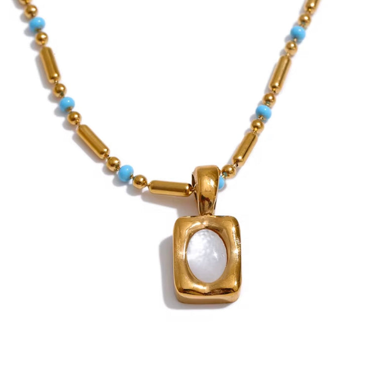 Close-up of April gold necklace showing small pendant and turquoise beads