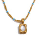 Close-up of April gold necklace showing small pendant and turquoise beads