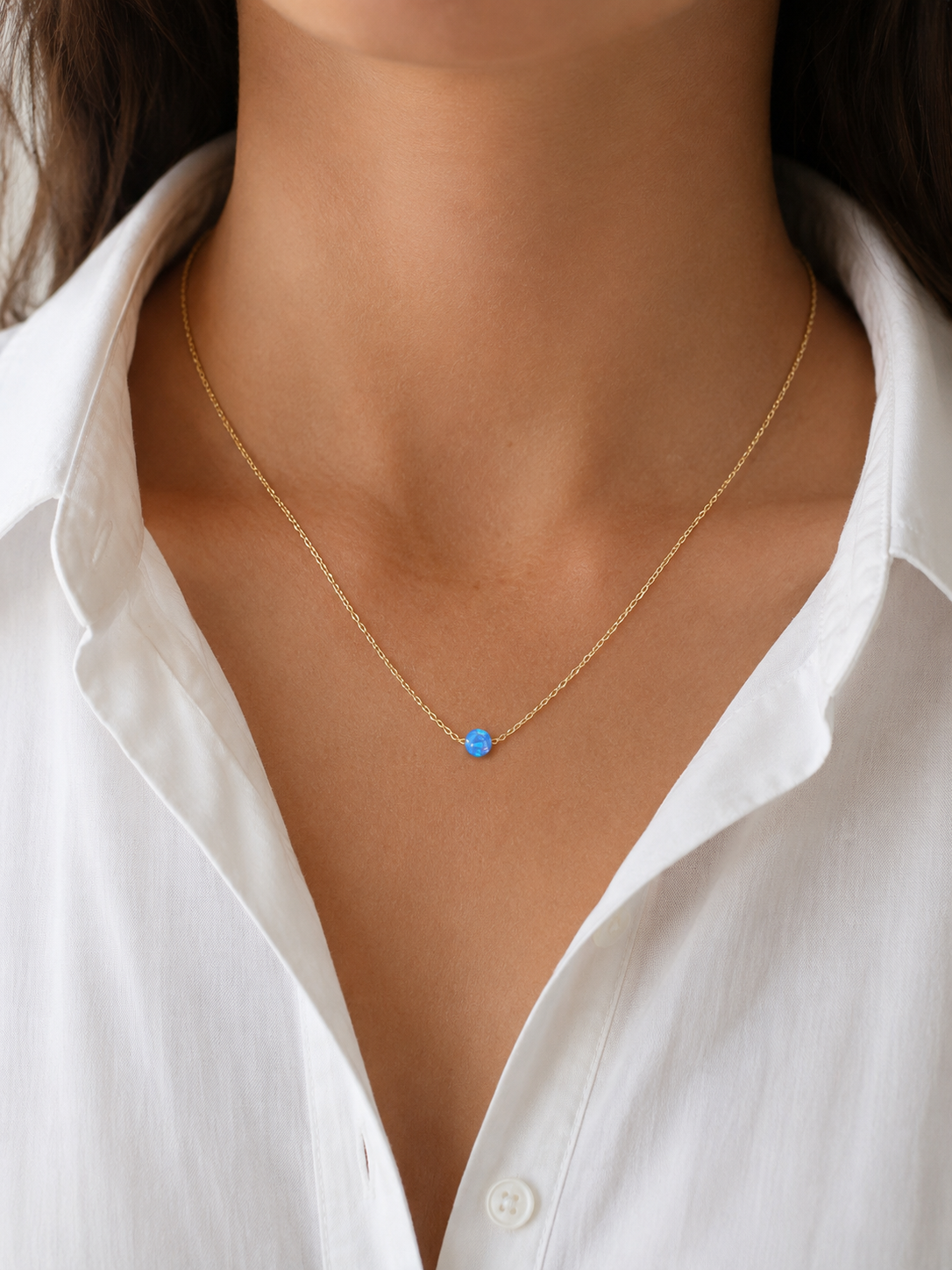 Model wearing the Azure Opalite Necklace layered with a white blouse