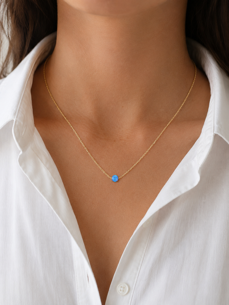 Model wearing the Azure Opalite Necklace layered with a white blouse