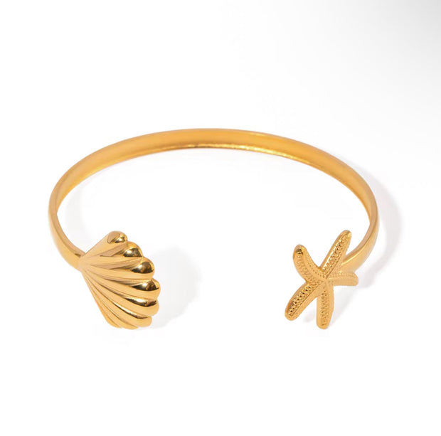 Gold bangle bracelet with starfish and seashell design