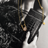 Modern gold Bianka necklace with sparkling multi-cut cubic zirconia pendant styled on a fashion editorial background.