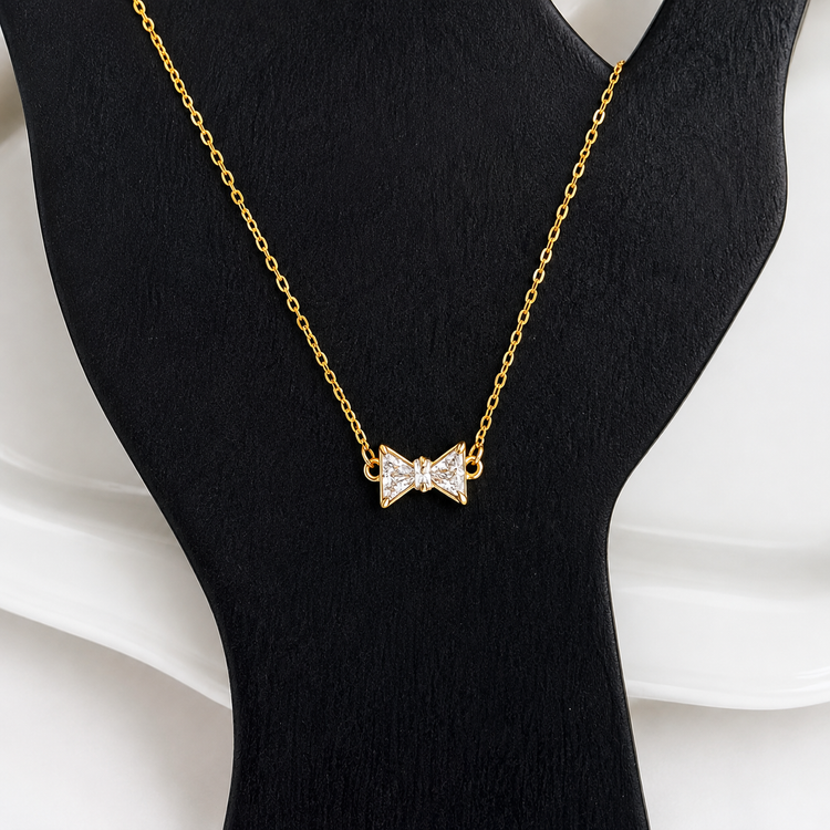 Gold Bow Rhinestone Necklace displayed on a black jewelry bust showing the rhinestone bow pendant
