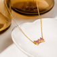 Bow Rhinestone Necklace displayed on a white jewelry dish with pink rhinestone bow pendant