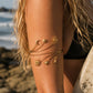 Woman wearing the Gold Celestial Upper Arm Cuff Bracelet on the beach featuring a sun moon and star design