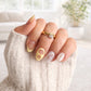 Model wearing the Cerise Ring, a gold twisted band ring with oval cubic zirconia center