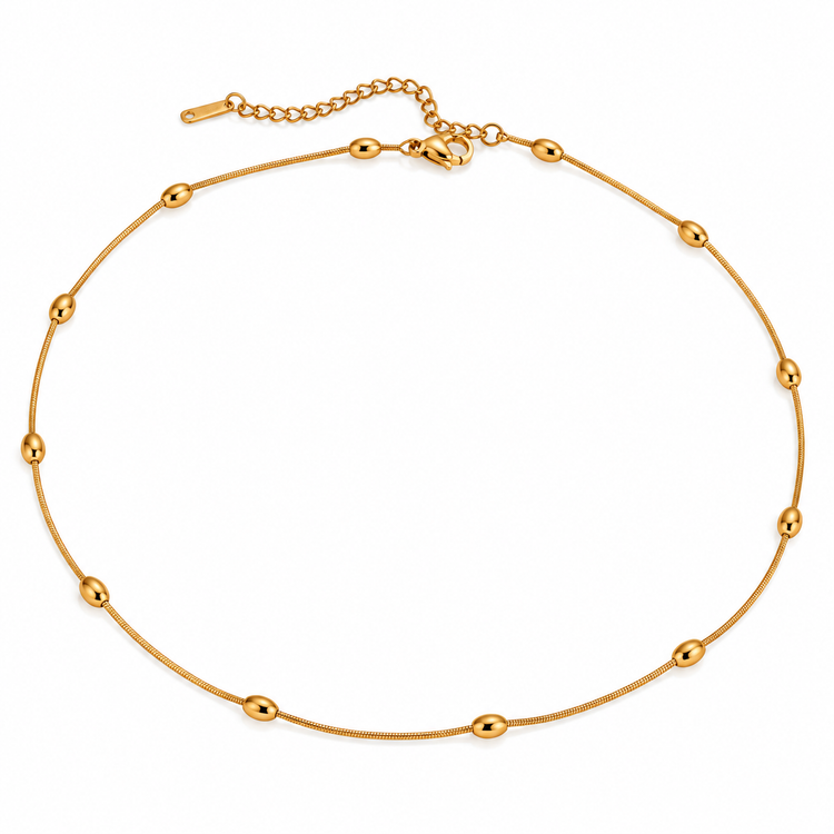 Gold snake chain necklace with oval bead accents shown in a flatlay