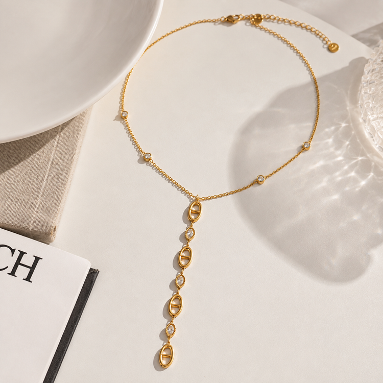 Flat lay of the Christina Drop Necklace showcasing gold oval links and sparkling cubic zirconia details.