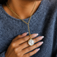 Close-up of the Dawn gold pendant necklace highlighting the sun-inspired design