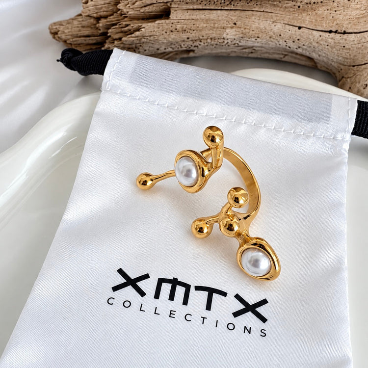 Ellen Modern gold statement ring with faux pearl accents displayed on an XMTX Collections satin jewelry pouch.