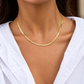 Embossed gold herringbone necklace worn on model, featuring a sleek textured chain design