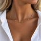 Gold oval bead snake chain necklace worn on a woman