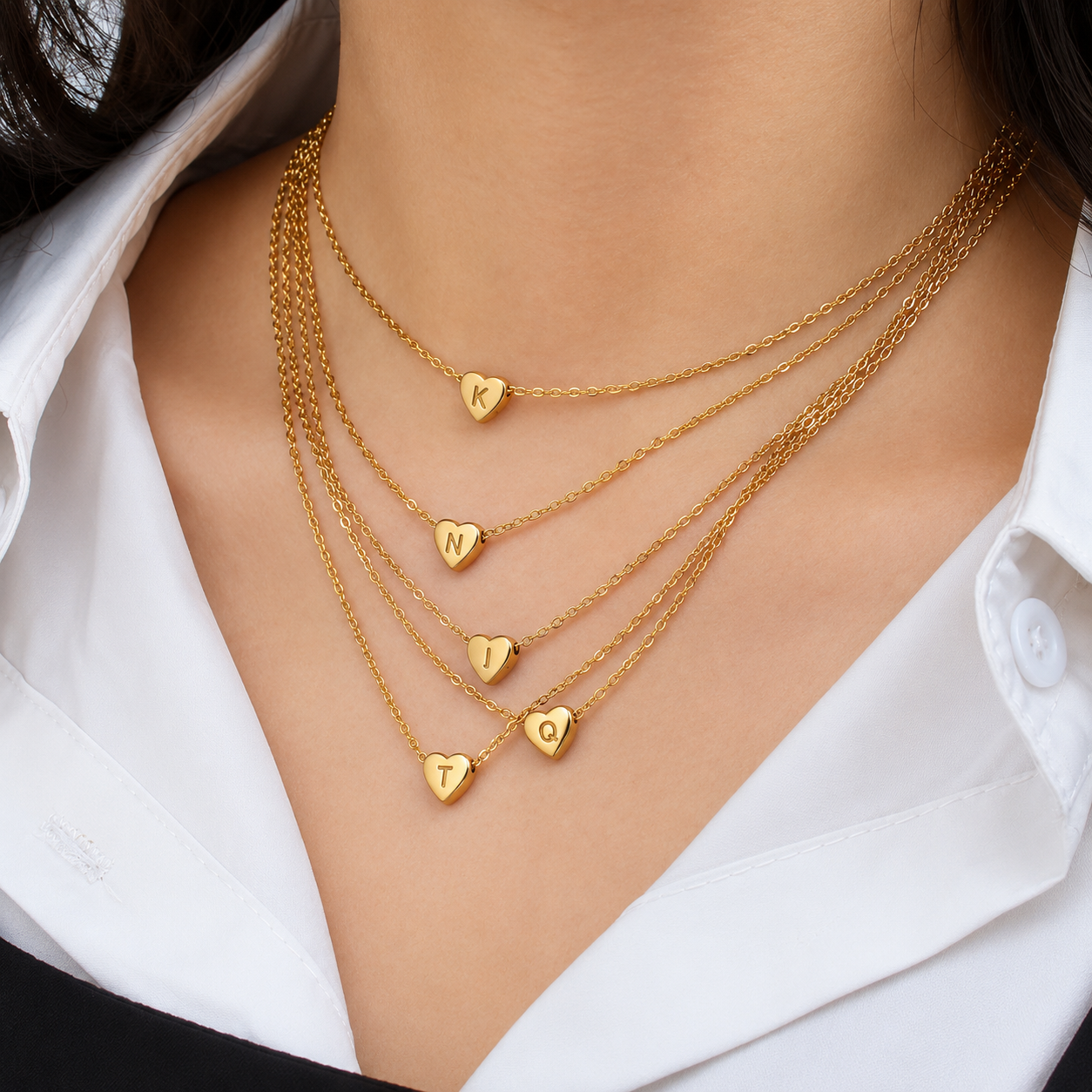 Model wearing layered waterproof gold Heart Initial Necklaces. Personalized, non-tarnish everyday jewelry by XMTX Collections.