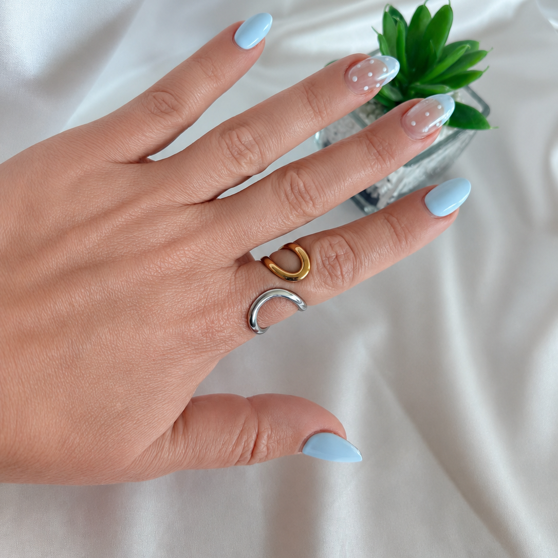 Woman wearing June Two Tone Open Ring with blue manicure and satin backdrop