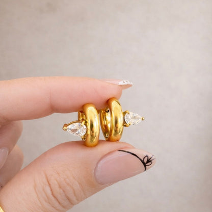 Elle Huggies gold teardrop stone huggie earrings close-up in hand