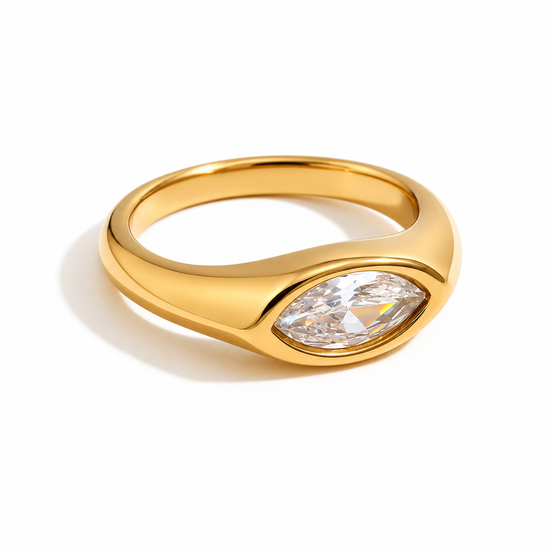 A polished yellow gold ring featuring a marquise-cut clear gemstone, shown on a clean white background with a soft shadow.
