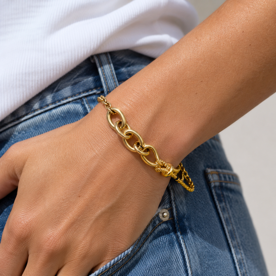 Model wearing the waterproof Mariner Knot gold chain bracelet styled with blue denim jeans