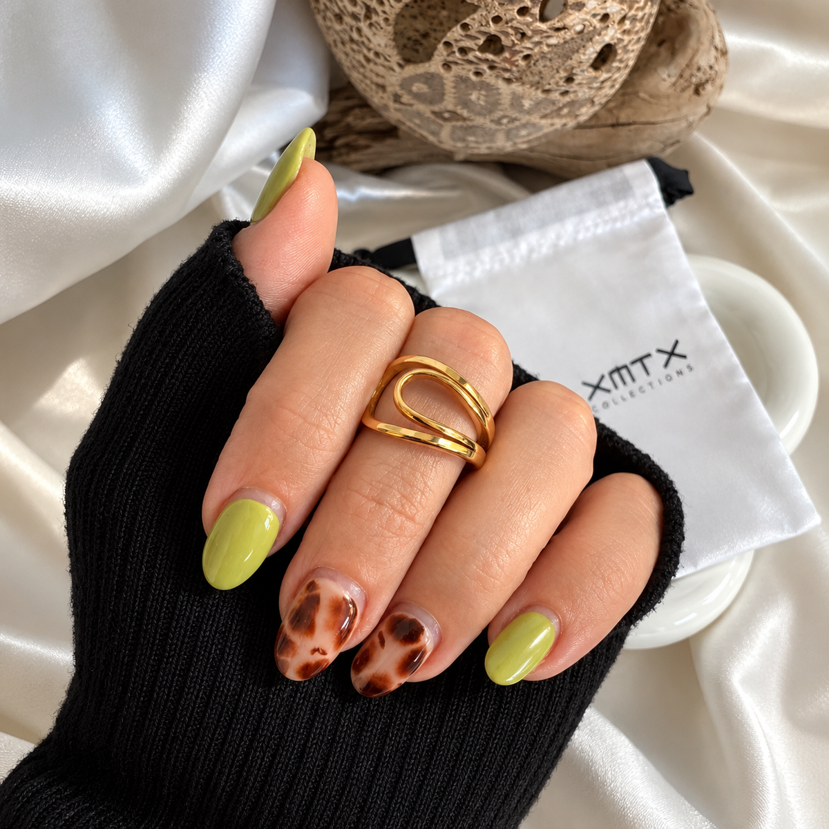 Nico Sculptural gold ring worn on a hand, showing its modern open wraparound design