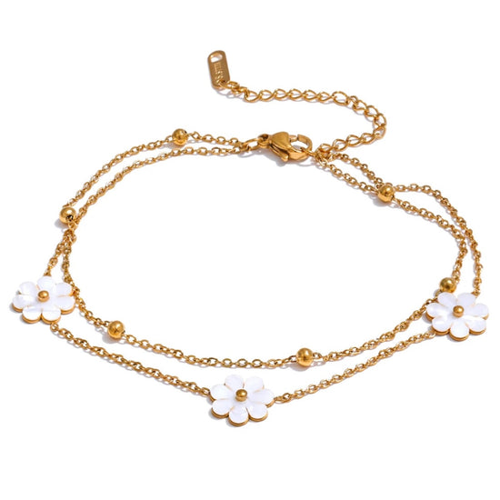 Add a touch of whimsy to your outfit with our Mother of Pearl Flowers Anklet. Delicate and dainty, this anklet features pretty, natural shell flowers that will elevate any look. Perfect for those who want to add a fun and playful touch to their style.

&nbsp;

This piece is made to last, hypoallergenic anti tarnish &amp; water resistant&nbsp;

316L Stainless Steel 18K Gold Plated

8.5 inches long +2 inches ext