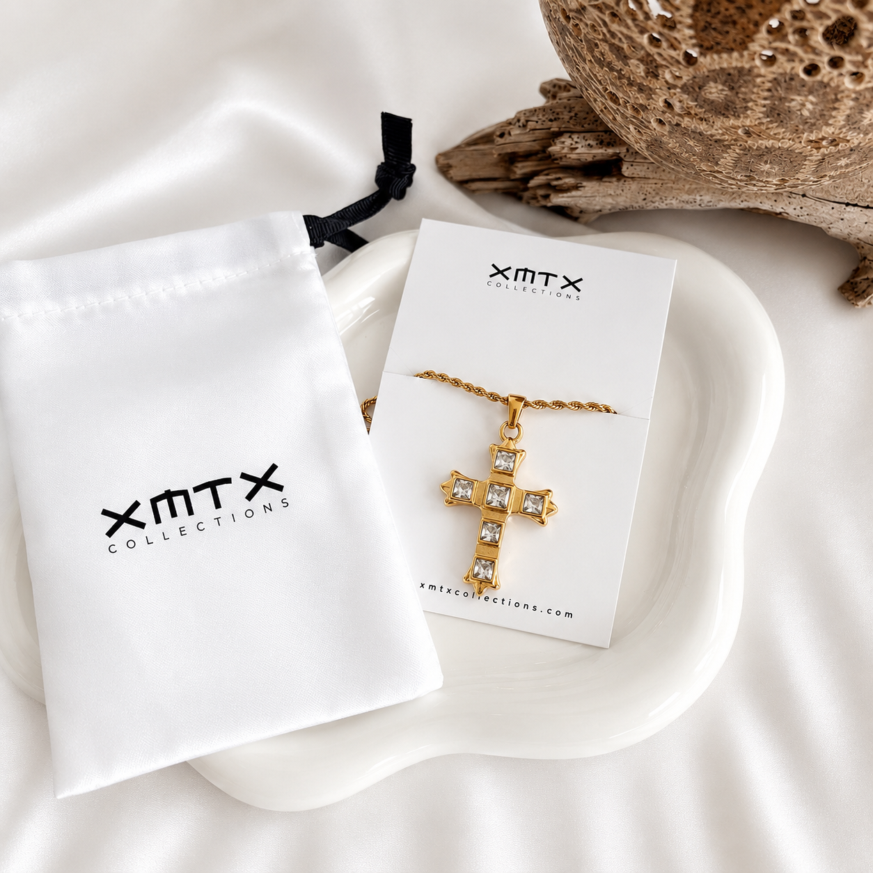 Gold cross necklace displayed with XMTX Collections jewelry packaging