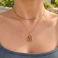 Poppy Wishbone Necklace worn as a gold floral pendant necklace with red flower, pearl and green leaves