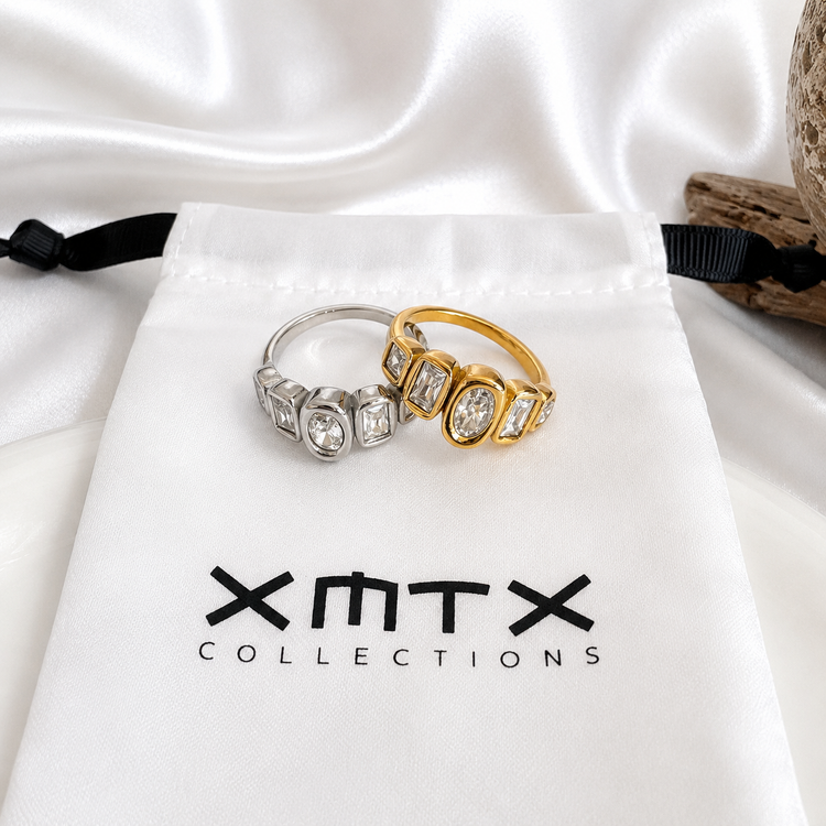 Sadie five-stone statement rings in gold and silver displayed on XMTX Collections jewelry pouch