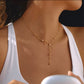 Woman wearing the Saya gold Y necklace with crystal accents and a white tank top