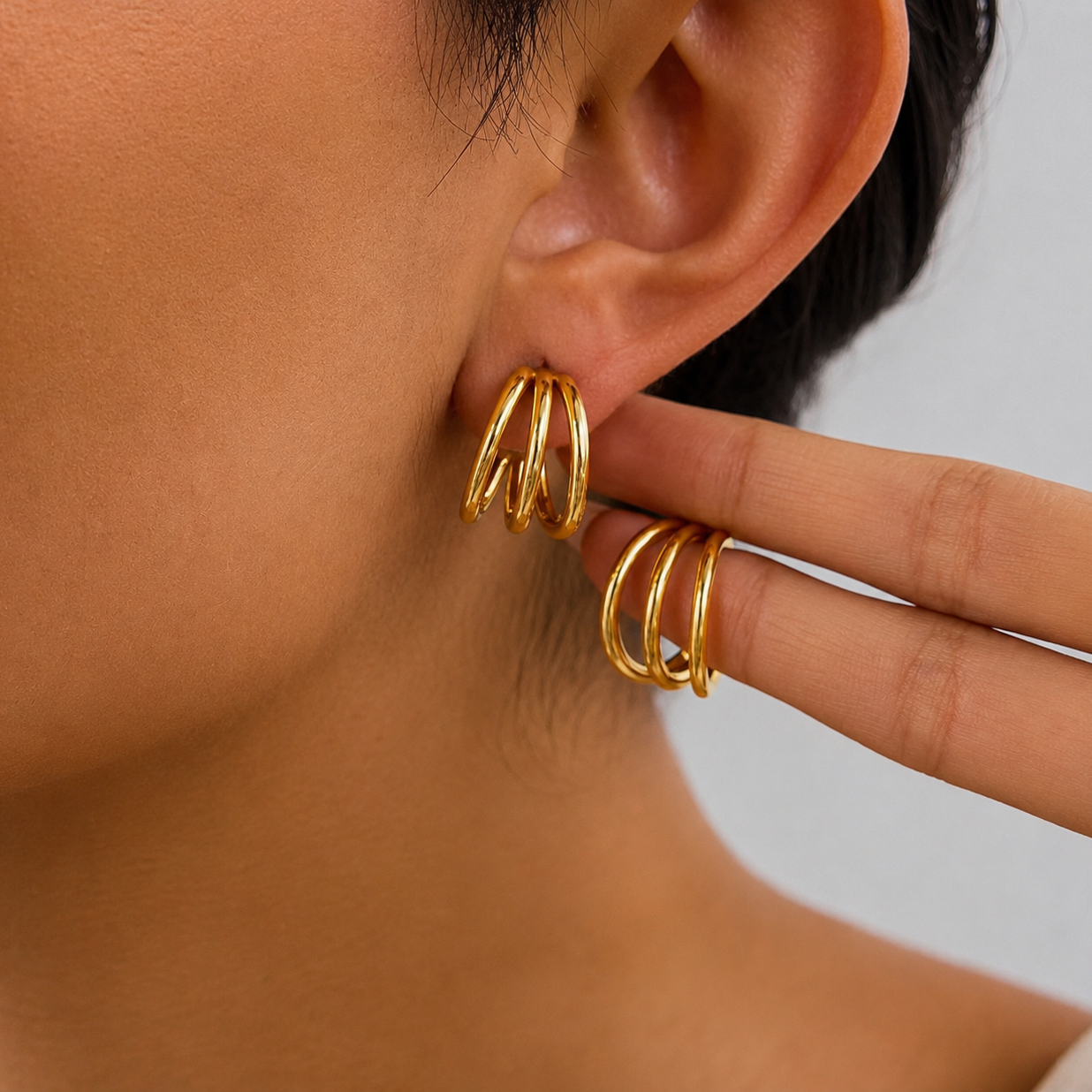 Model wearing Shanti triple gold hoop earrings with a bold stacked design for an effortless statement ear look.