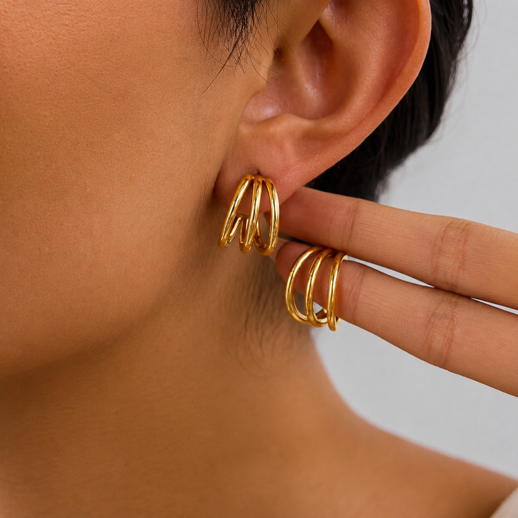 Model wearing Shanti triple gold hoop earrings with a bold stacked design for an effortless statement ear look.