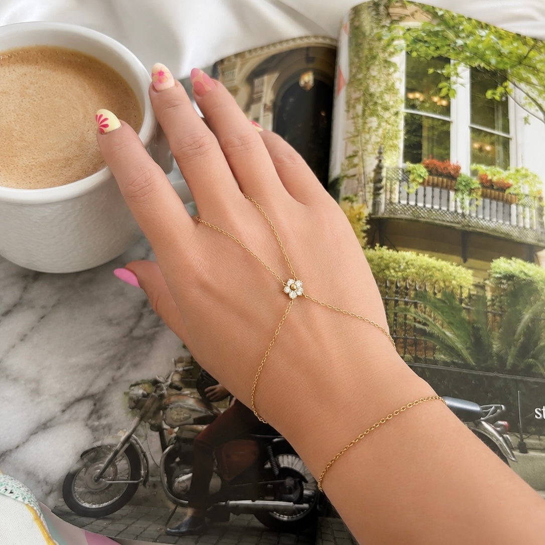 Model wearing the Single Flower Hand Chain featuring a sparkling cubic zirconia flower in 18K Gold PVD-plated stainless steel. Waterproof, non-tarnish, hypoallergenic jewelry for everyday wear.