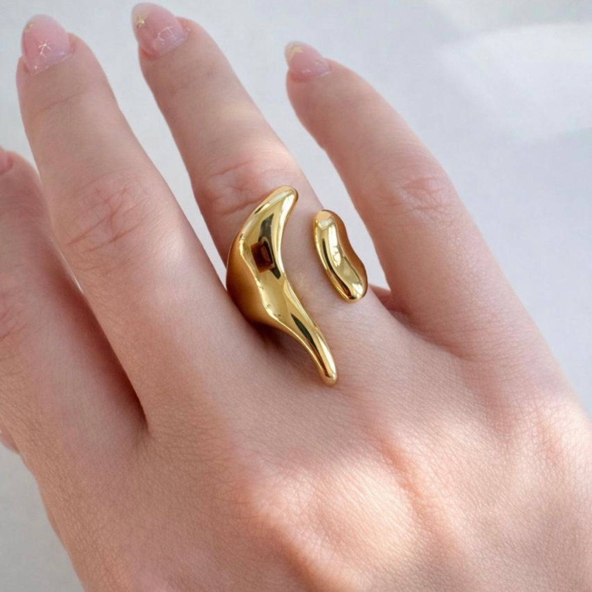 Gold open-end statement ring with organic molten design worn on hand, made of polished stainless steel, non-tarnish and waterproof by XMTX Collections
