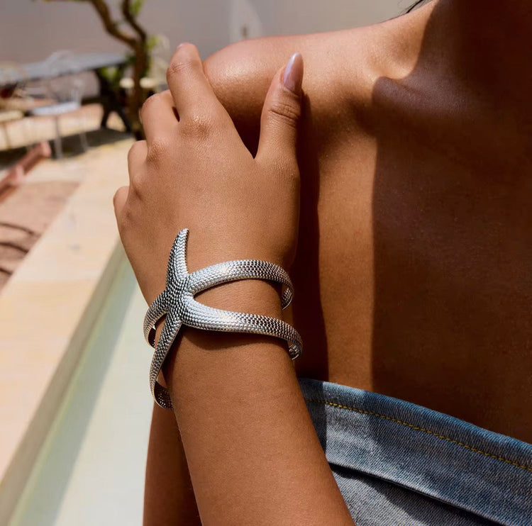 Starfish bangle bracelet worn on wrist silver textured cuff jewelry