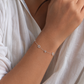 Woman wearing sterling silver pavé Mogen David LOVE bracelet in natural lighting