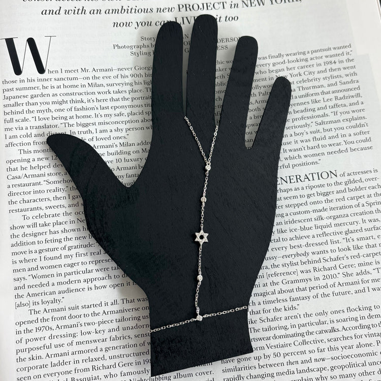 Sterling silver Star of David hand chain displayed on a jewelry hand stand highlighting its elegant adjustable design