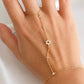 Sterling silver Star of David hand chain with clear cubic zirconia accents shown worn on the hand in a gold finish.